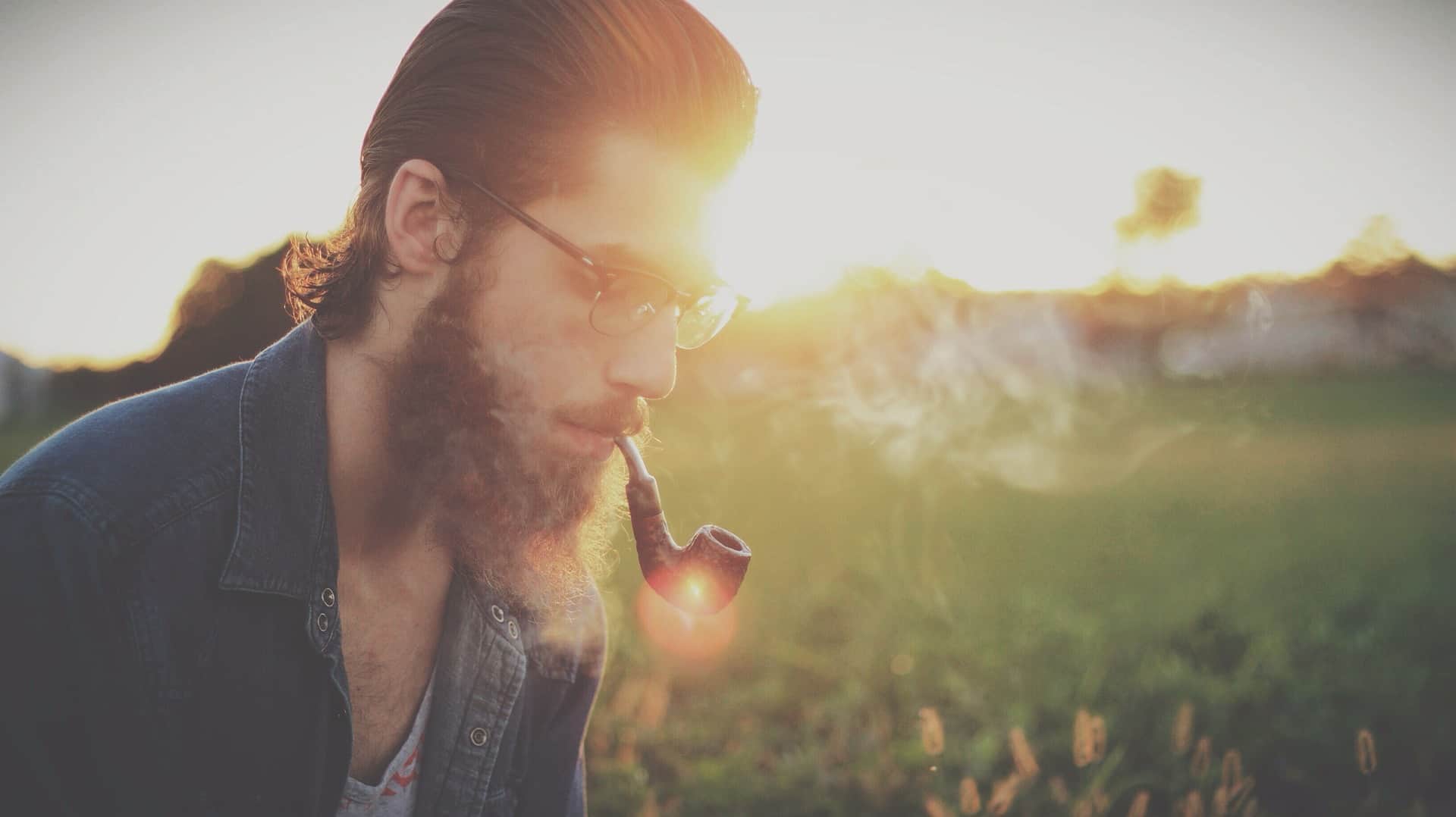 Man wearing glasses and smoking a pipe