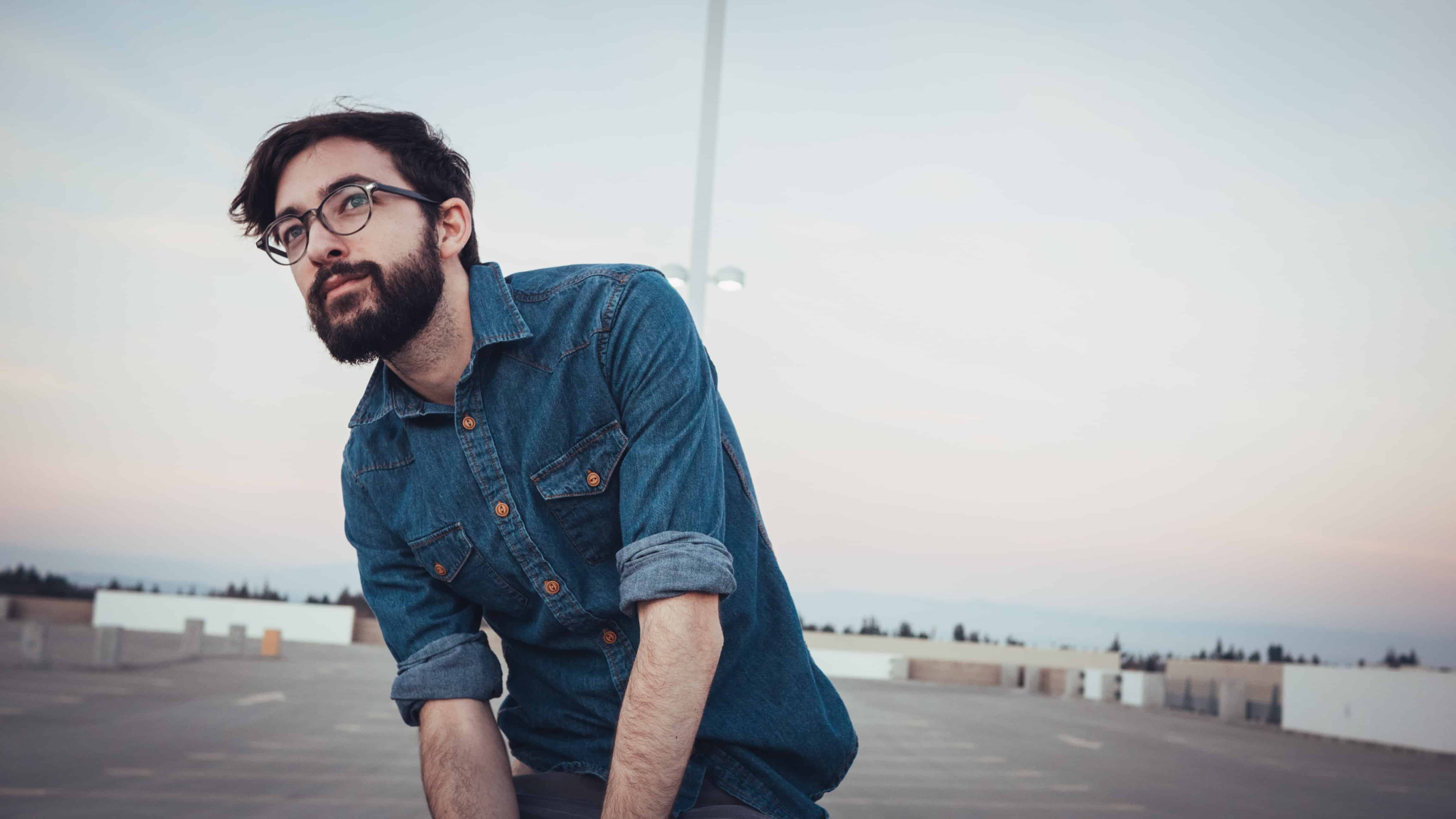 man wearing denim sport shirt and sunglasses on concrete flooring