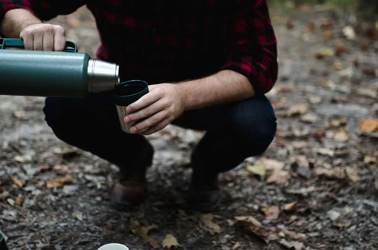 person pouring thermos in a cup
