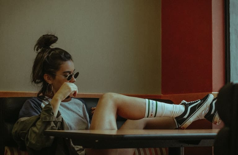 A girl sitting while her foot is on the table