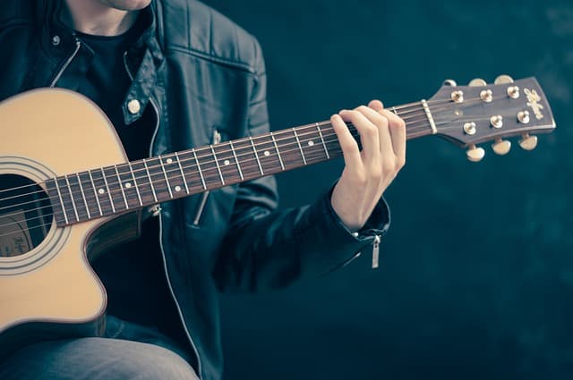 person guitarist playing guitar